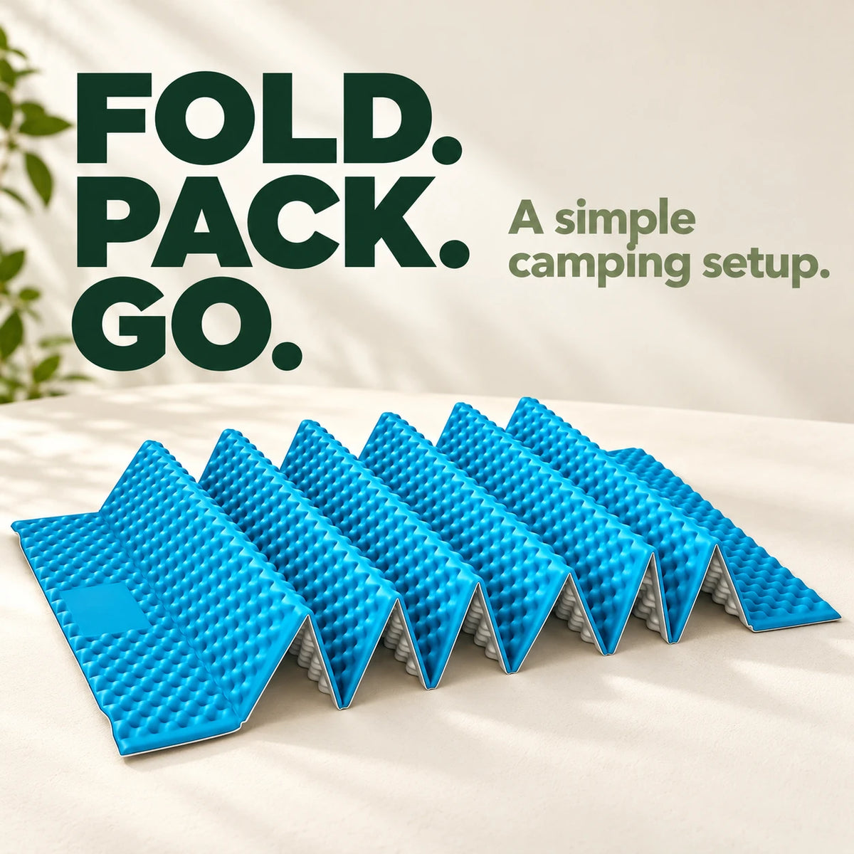 Sky-blue and silver accordion camping mat on a cream tabletop.