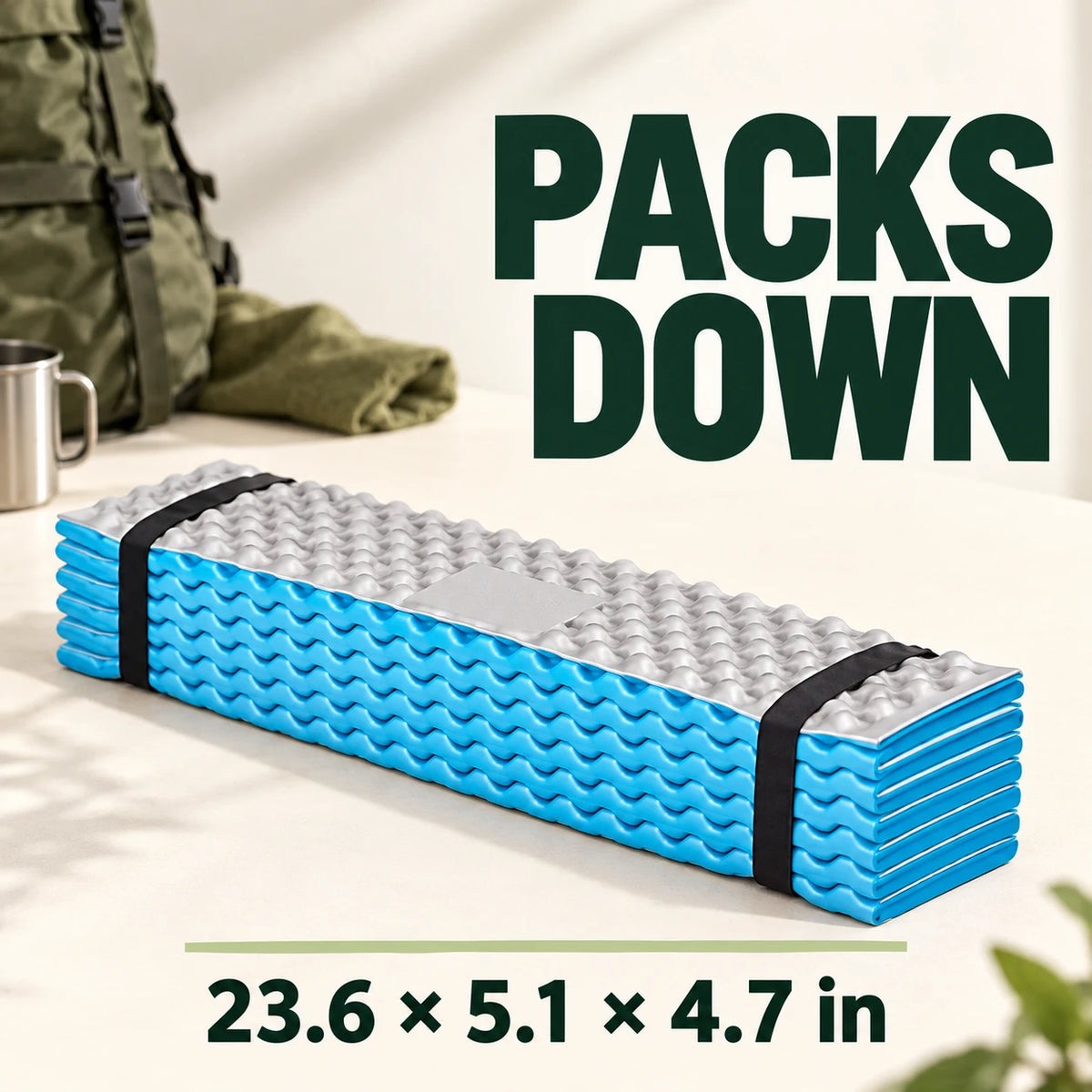 Folded sky-blue and silver camping mat with two black straps.