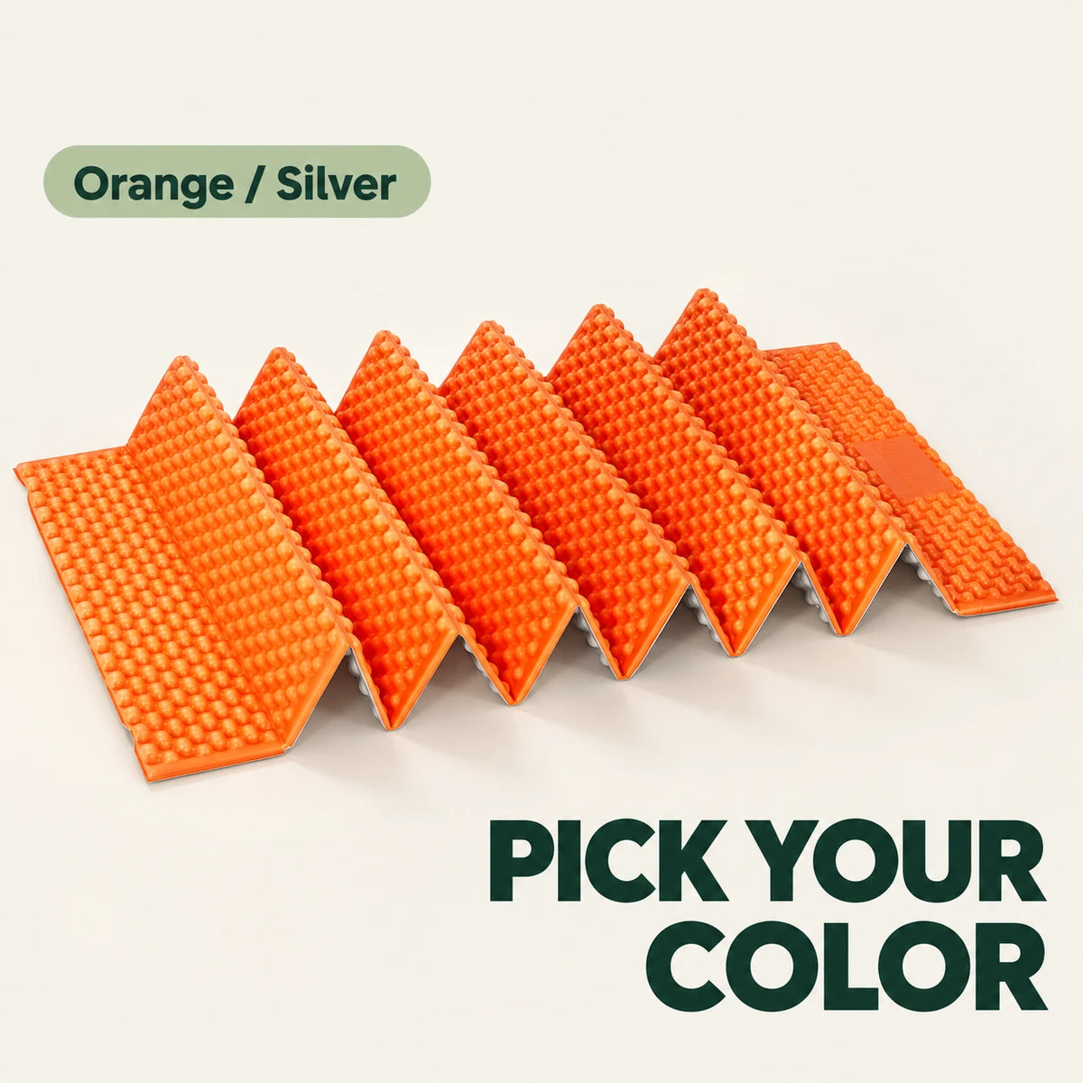 Orange and silver accordion camping mat resting on a cream surface.